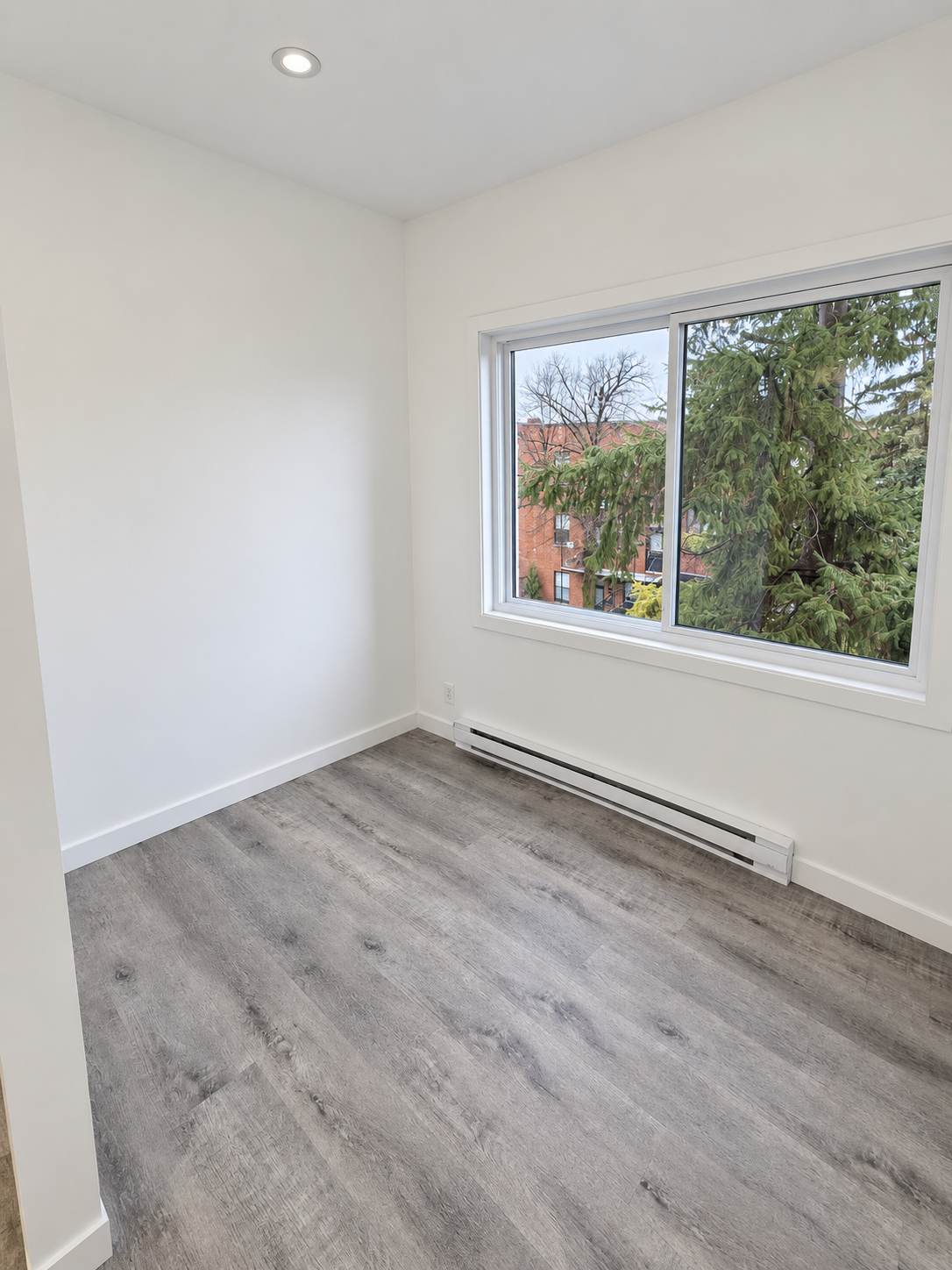 Pièce entièrement rénovée avec plancher et fenêtre neufs — projet réalisé par Maison Craft
